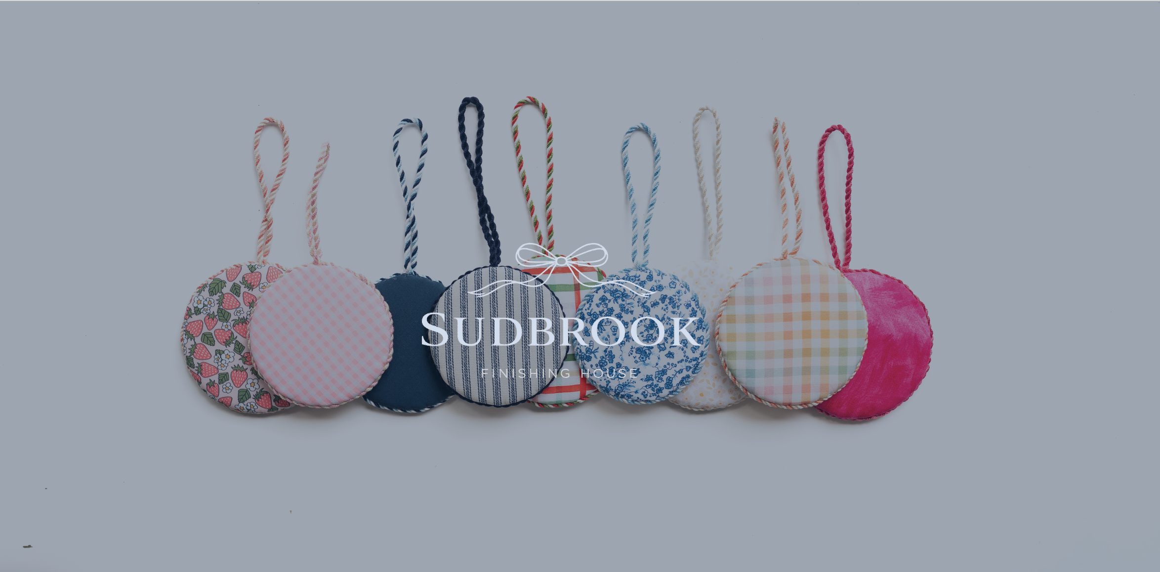 Hand-finished needlepoint ornaments by Sudbrook Finishing House featuring curated fabrics and cording.
