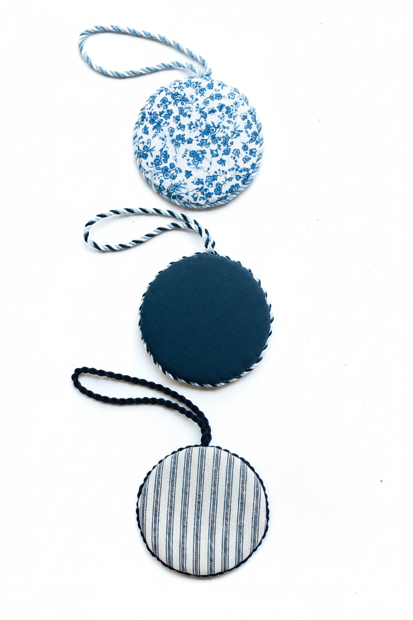 Blue collection of hand-finished needlepoint ornaments in curated fabrics and classic finishing styles.