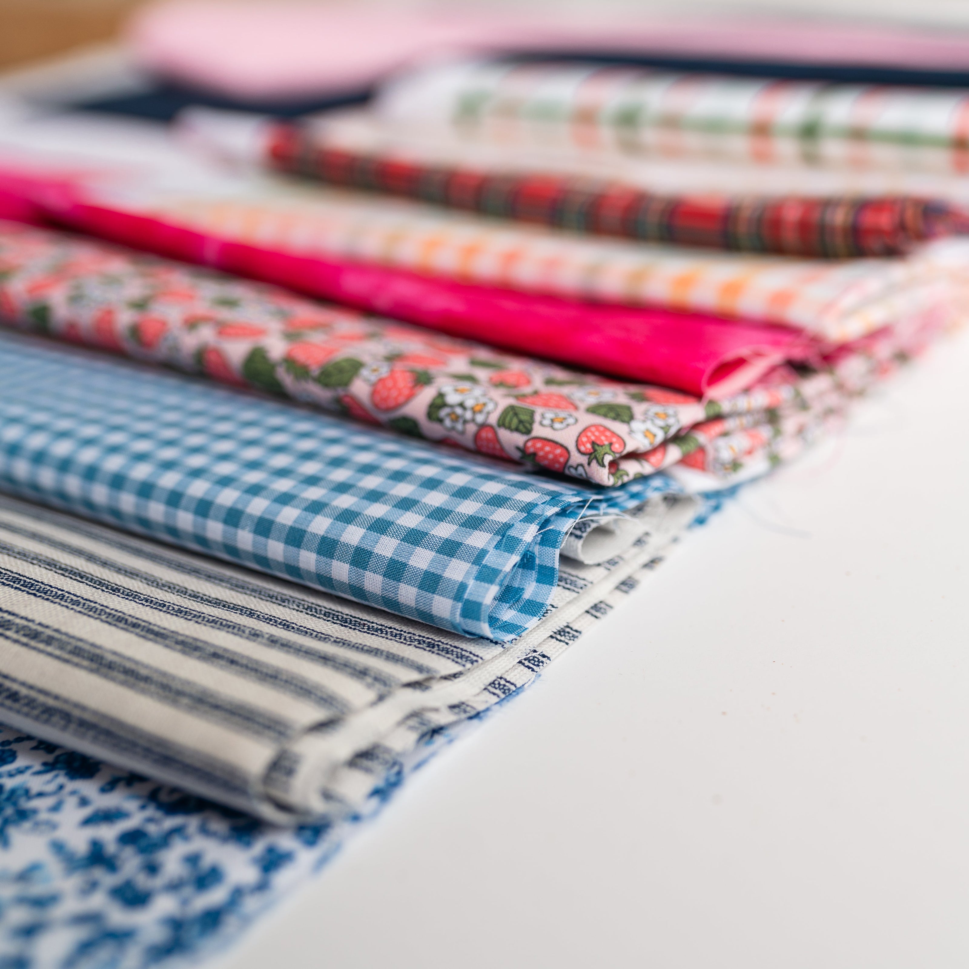 Curated fabric options for custom needlepoint finishing, including gingham, plaid, and classic solids.